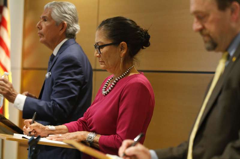 Former U.S. Interior Secretary Deb Haaland, a Democratic candidate for governor of New Mexico, takes notes in the midst of a candidate forum in Rio Rancho, N.M., on April 28, 2026, while standing between Republican candidates Duke Rodrigquez, left, and Gregg Hull, right. (AP Photo/Morgan Lee)